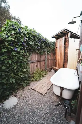 a toilet sitting on the ground next to a fence at TinyHome at the Sanctuary in Lakeside