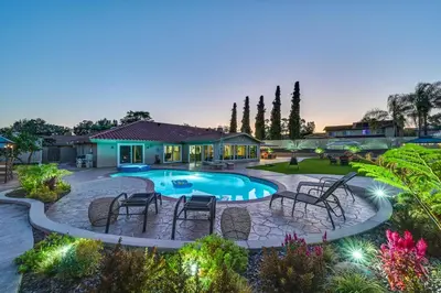 a backyard with a pool and chairs and a house at Luxe Family Home in Bonita with Private Pool and Spa! in Bonita
