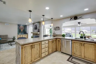 an open kitchen with wooden cabinets and stainless steel appliances at Luxe Family Home in Bonita with Private Pool and Spa! in Bonita