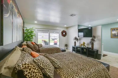 two beds in a bedroom with cheetah sheets at Luxe Family Home in Bonita with Private Pool and Spa! in Bonita