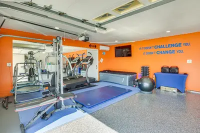 a gym with an orange wall and a treadmill at Luxe Family Home in Bonita with Private Pool and Spa! in Bonita