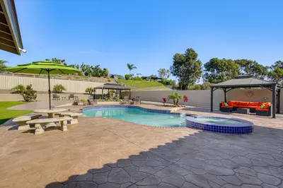 a swimming pool with a picnic table and an umbrella at Luxe Family Home in Bonita with Private Pool and Spa! in Bonita