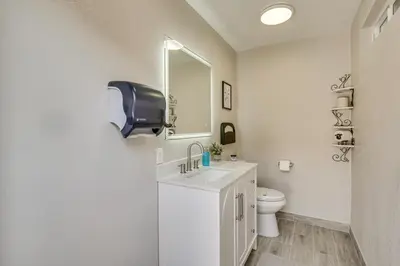 a white bathroom with a sink and a toilet at Luxe Family Home in Bonita with Private Pool and Spa! in Bonita