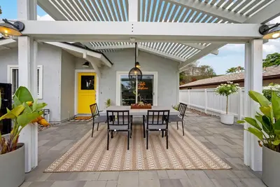 a patio with a table and chairs under a white pergola at Colorful & Comfy Gem Close to Beach - Yard - Pkg in Encinitas