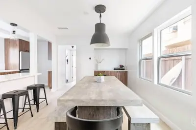 a kitchen and dining room with a large table and stools at Beach Home W AC- 5 BR - Free Parking - EV Charge in San Diego