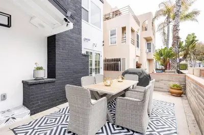 a patio with a wooden table and chairs at Beach Home W AC- 5 BR - Free Parking - EV Charge in San Diego
