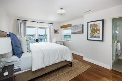 a white bedroom with a bed and a window at 608 S Bayfront in Newport Beach