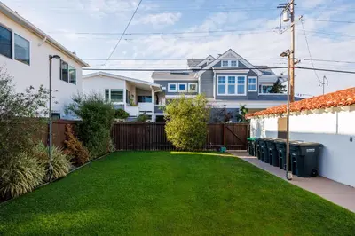 a backyard with a green lawn and a house at 608 S Bayfront in Newport Beach