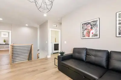 a living room with a black leather couch at The Lake Stay in Menifee