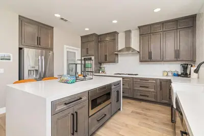 a kitchen with wooden cabinets and white counter tops at The Lake Stay in Menifee