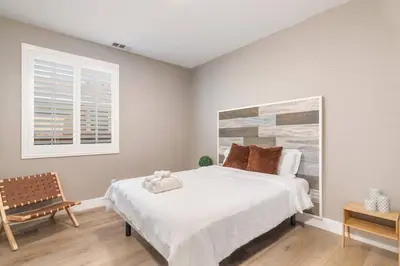 a bedroom with a large white bed and a window at The Lake Stay in Menifee