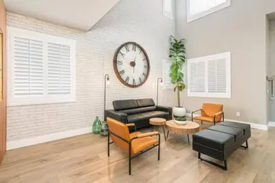 a living room with a couch and a clock on the wall at The Lake Stay in Menifee