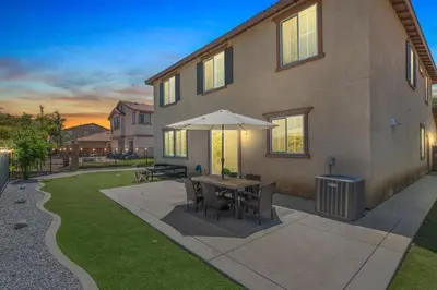 a table with an umbrella outside of a house at The Lake Stay in Menifee