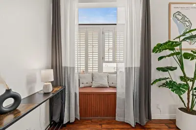 a room with a window with a bench and a plant at Grand Desire - Vibrant - Luxury - Beachside treat in San Diego