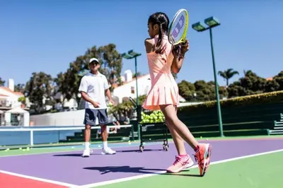 a woman holding a tennis racket on a tennis court at Luxury Villa at Omni La Costa Resort & Spa in Carlsbad