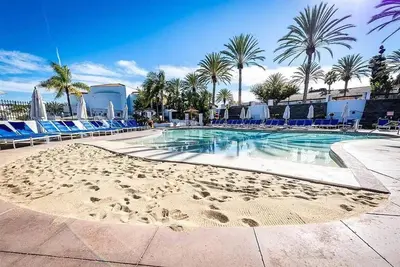 a swimming pool with chairs and a sandy beach at Luxury Villa at Omni La Costa Resort & Spa in Carlsbad