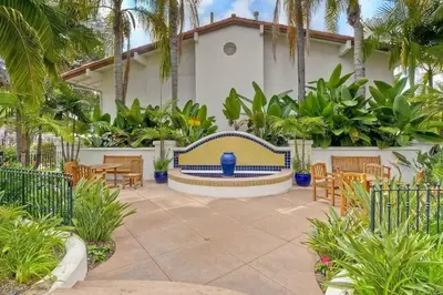 a patio with a bench and tables and palm trees at Luxury Villa at Omni La Costa Resort & Spa in Carlsbad