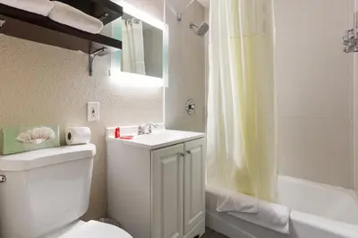 a bathroom with a toilet and a sink and a tub at Hotel Aqua Mar in San Diego
