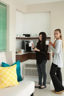 two women standing in a living room eating food at Hotel Aqua Mar in San Diego