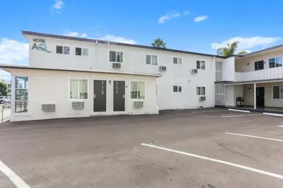 a large white building with a parking lot at Hotel Aqua Mar in San Diego