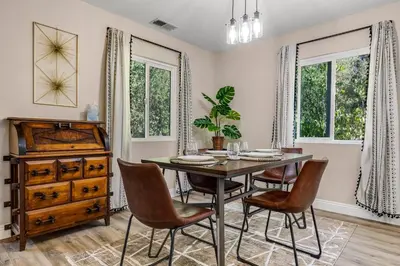 a dining room with a table and chairs and windows at Buckthorn Beauty Private Hot Tub and Lounge Space in Pine Valley