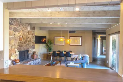 a living room with a large stone fireplace at Pool and Mtn View! Designer Borrego Springs Hideaway in Borrego Springs