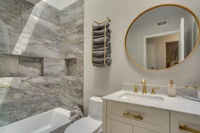 a bathroom with a tub and a sink and a mirror at Laguna Niguel Townhouse with Community Pool Access! in Laguna Niguel