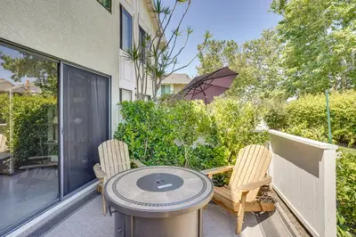 a patio with two chairs and a table and an umbrella at Laguna Niguel Townhouse with Community Pool Access! in Laguna Niguel