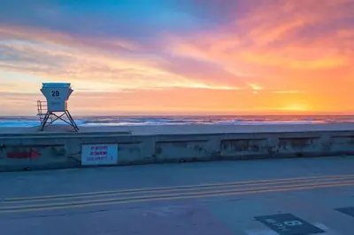 a watch tower on the beach at sunset at Beach-2-Bay 1br - Mission Beach - AC - Shops in San Diego