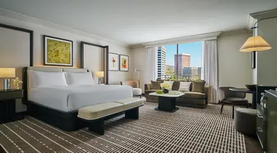 a hotel room with a bed and a living room at Pendry Newport Beach in Newport Beach