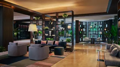 a lobby with couches and plants in a building at Pendry Newport Beach in Newport Beach