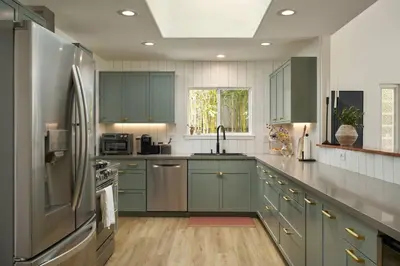 a kitchen with green cabinets and a stainless steel refrigerator at Coastal Retreat with E-Bikes! in Carlsbad