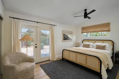 a bedroom with a bed and a chair and a window at Coastal Retreat with E-Bikes! in Carlsbad