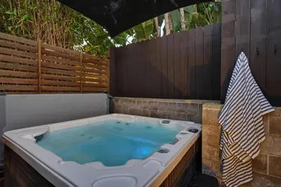 a hot tub in a backyard with a fence at Coastal Retreat with E-Bikes! in Carlsbad