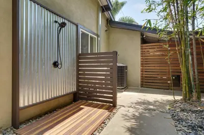 a wooden bench sitting outside of a house at Coastal Retreat with E-Bikes! in Carlsbad