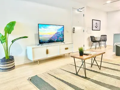 a living room with a flat screen tv on a white cabinet at Boutique Suite in Downtown San Diego in San Diego