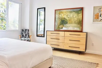 a bedroom with a dresser and a painting on the wall at Dapper Retreat in Vibrant San Diego in San Diego