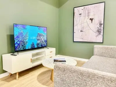 a living room with a large flat screen tv at Dapper Retreat in Vibrant San Diego in San Diego
