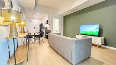 a living room with a couch and a tv at Dapper Retreat in Vibrant San Diego in San Diego