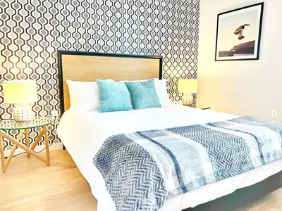 a bedroom with a large bed with blue pillows at The Leo - Unit 602 in San Diego