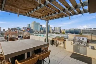 an outdoor patio with a table and a view of the city at 3 Bedroom Penthouse in Downtown! in San Diego