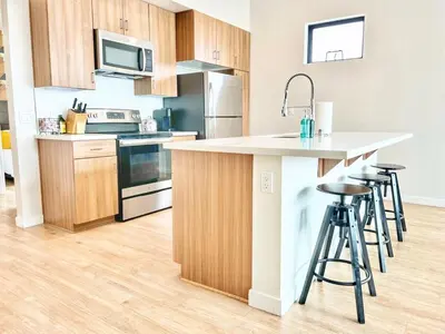 a kitchen with a counter and stools in it at 3 Bedroom Penthouse in Downtown! in San Diego