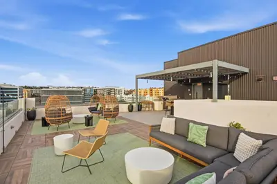 a rooftop patio with couches and tables and chairs at One Bedroom Apartment wBalcony and City Views! in San Diego