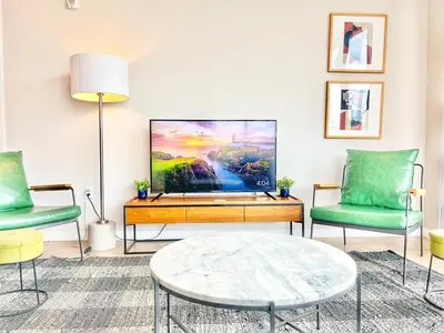 a living room with two chairs and a flat screen tv at The Leo - Deluxe 3 Bedroom Stay in San Diego