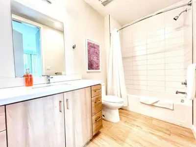 a bathroom with a sink and a toilet and a tub at The Leo - Deluxe 3 Bedroom Stay in San Diego