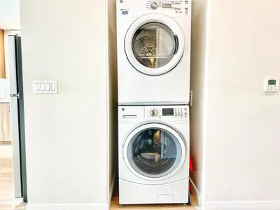 a washer and dryer next to a refrigerator at The Leo - Deluxe 3 Bedroom Stay in San Diego
