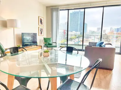 a living room with a glass table and chairs at The Leo - Deluxe 3 Bedroom Stay in San Diego