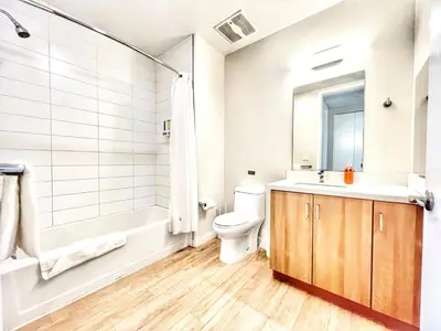 a bathroom with a sink and a toilet and a tub at The Leo - Deluxe 3 Bedroom Stay in San Diego