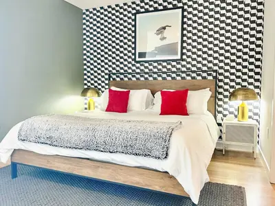 a bedroom with a large bed with red pillows at Hidden Gem Apartment in Downtown in San Diego