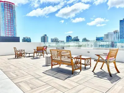 a group of chairs and tables on the roof of a building at Hidden Gem Apartment in Downtown in San Diego